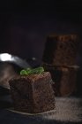 Pedaços de chocolate brownie com hortelã no fundo escuro — Fotografia de Stock