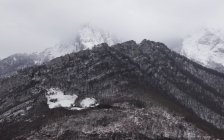 Gamma di montagne fredde scure con neve e nebbia — Foto stock