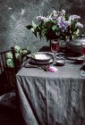 Mantel con alcachofas, flores y vino tinto - foto de stock