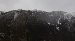 Gama de montañas frías oscuras con nieve y neblina - foto de stock