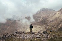 Homem de pé na montanha entre nevoeiro — Fotografia de Stock