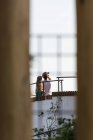 Задний вид неузнаваемой пары, стоящей на крыше и делающей селфи с фотокамерой — стоковое фото