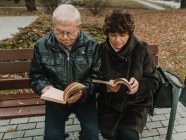 Seniorenpaar liest Bücher im Park — Stockfoto