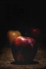 Fresh apples on wooden table on dark background — Stock Photo