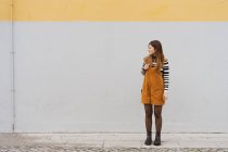 Young smiling woman near grey wall — Stock Photo