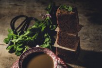 Pezzi impilati di brownie al cioccolato con menta sul tavolo di legno — Foto stock