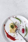 Спагетті з томатним песто і соусом на виделці на білому тлі — стокове фото