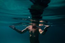 Homem com relógio subaquático em acenando mar azul — Fotografia de Stock