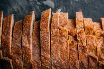 Fatias de pão rústico caseiro no fundo escuro — Fotografia de Stock