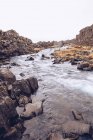 Água no rio que corre entre rochas na Islândia — Fotografia de Stock