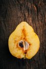 Medio de fruta de membrillo sobre fondo de madera oscura - foto de stock