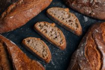 Домашний рустик хлеба хлеба с ломтиками на темном фоне — стоковое фото