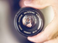 Reflection of woman in lens — Stock Photo