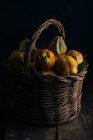 Marmelos frescos colhidos em cesta no fundo de madeira escura — Fotografia de Stock