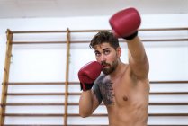 Jovem homem confiante boxe no ginásio — Fotografia de Stock