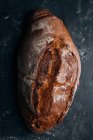 Homemade rustic bread loaf on dark background — Stock Photo