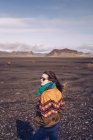 Улыбаясь человеку, стоя между темными землями Исландии — стоковое фото