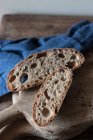 Кусочки хлеба из цельной муки на деревенской деревянной доске — стоковое фото