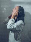 Woman dressed in wet shirt posing in shower — Stock Photo