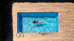 Anonymous woman swimming in pool — Fotografia de Stock