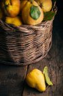 Fresh picked quinces in basket on dark wooden background — Stock Photo