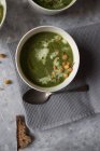 Ciotola con zuppa di spinaci, cavolo e crema di finocchio su superficie grigia — Foto stock