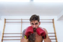 Jovem homem confiante boxe no ginásio — Fotografia de Stock