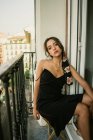 Ritratto di affascinante signorina in abito seduta sul balcone — Foto stock