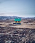 Красочный дом на коричневом поле между землями смерти и каменными холмами в Исландии — стоковое фото