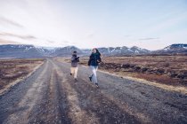 Couple running on road between death lands — Stock Photo