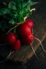 Bunch of fresh radishes on wooden background — Stock Photo