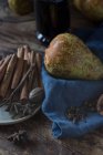 Pear and spices on blue towel near bottle of wine — Fotografia de Stock