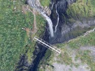 Мост через впечатляющий ущелье и водопад в природе — стоковое фото