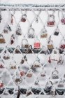 Hoarfrost blanco que cubre candados de amor y cerca de red en el día de invierno en el parque - foto de stock