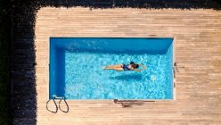 Femme anonyme nageant dans la piscine — Photo de stock