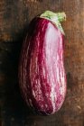 Fresh ripe striped eggplant on wooden table — Stock Photo