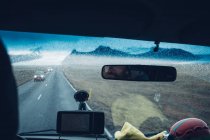Hombre conduciendo coche en llanura remota - foto de stock