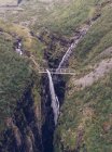 Bridge over spectacular ravine and waterfall in nature — Stock Photo