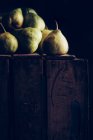 Saftige und reife Birnen auf dunklem Holzgrund — Stockfoto