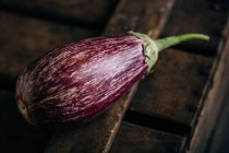 Fresh ripe striped eggplant on wooden table — Stock Photo