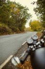 Крупним планом мотоцикл на дорозі в осінній сільській місцевості — стокове фото