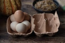 Close-up of eggs and ingredients for delicious pumpkin and spinach frittata on timber tabletop — Stock Photo