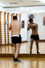 Бородатый боец тренируется в спортзале против зеркала — стоковое фото