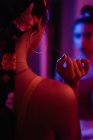 Visão traseira apaixonada atraente mulher morena com brinco e filé na cabeça e reflexão no espelho na vermelhidão — Fotografia de Stock