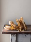 Heap of wheat pappardelle spaghetti on old wood table on grey background — Stock Photo