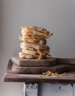 Pile di pappardelle spaghetti di grano su vecchio tavolo di legno su fondo grigio — Foto stock