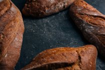 Caseiro pão rústico pães no fundo escuro — Fotografia de Stock