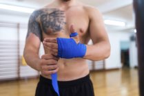 Крупным планом обёртывания рук боксера перед тренировкой в тренажерном зале — стоковое фото