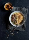 Oatmeal porridge with turmeric in bowl on dark background — Stock Photo