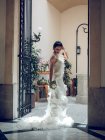 Sposa in piedi sulla porta di un edificio di lusso — Foto stock